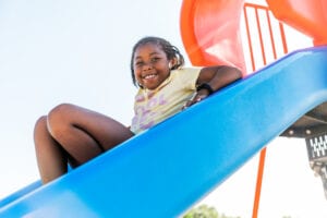 Student smiling on playground slide