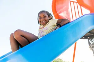 Student smiling on playground slide